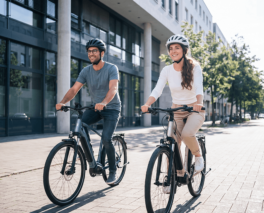Zwei Personen fahren mit dem Fahrrad durch die Stadt